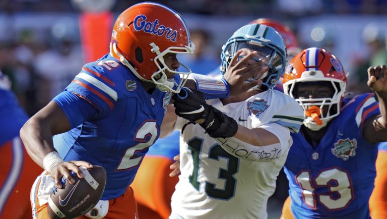 Florida quarterback DJ Lagway (2) stiff arms Tulane linebacker Tyler Grubbs (13) during the first half of the Gasparilla Bowl NCAA college football game Friday, Dec. 20, 2024, in Tampa, Fla.