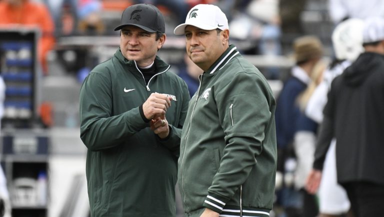 Michigan State head coach Jonathan Smith, left, talks with chief of staff, Dan Van De Riet, right, before the first half in an NCAA college football game against Illinois, Saturday, Nov. 16, 2024, in Champaign, Ill.