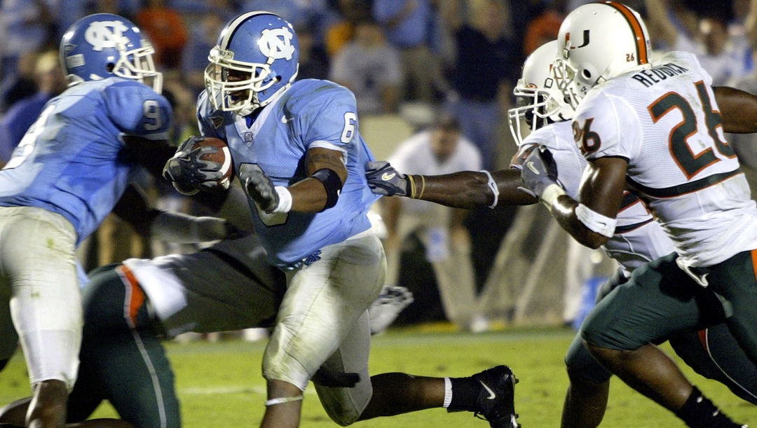 North Carolina's Chad Scott (6) breaks through Miami's Anthony Reddick (26) and Leon Williams, back, for a 9-yard touchdown run in the foruth quarter of North Carolina's 31-28 win in Chapel Hill, N.C., Saturday Oct. 30, 2004. Scott had 175 yards rushing and two touchdowns.