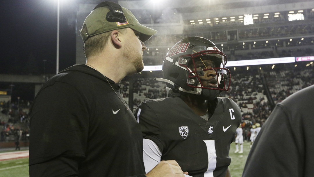 Washington State offensive coordinator Ben Arbuckle, left, speaks with quarterback Cameron Ward (1) during the second half of an NCAA college football game against Colorado, Friday, Nov. 17, 2023, in Pullman, Wash.