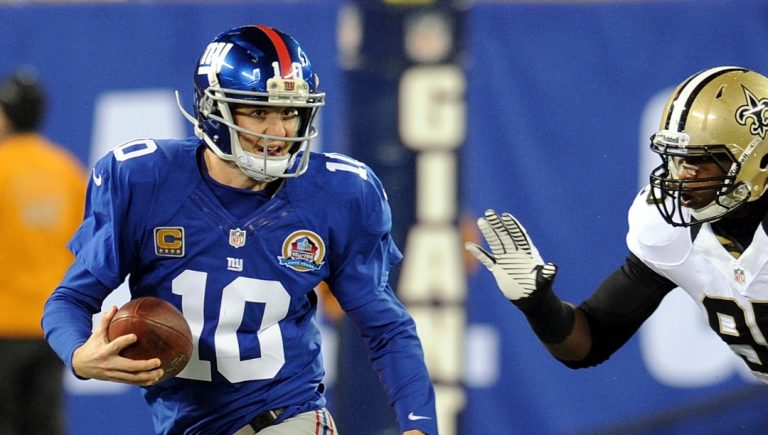 New York Giants quarterback Eli Manning is chased by New Orleans Saints Martez Wilson (95) during the first half of an NFL football game Sunday, Dec. 9, 2012, in East Rutherford, N.J. (AP Photo/Bill Kostroun)