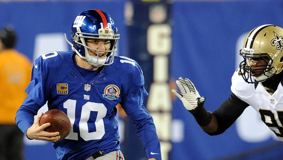 New York Giants quarterback Eli Manning is chased by New Orleans Saints Martez Wilson (95) during the first half of an NFL football game Sunday, Dec. 9, 2012, in East Rutherford, N.J. (AP Photo/Bill Kostroun)