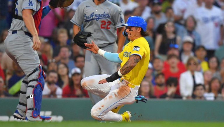 Boston Red Sox outfielder Jarren Duran, right, scores in front of Los Angeles Dodgers catcher Will Smith, left, on a sacrifice fly by Abraham Toro in the second inning of a baseball game, Saturday, July 26, 2025, in Boston.