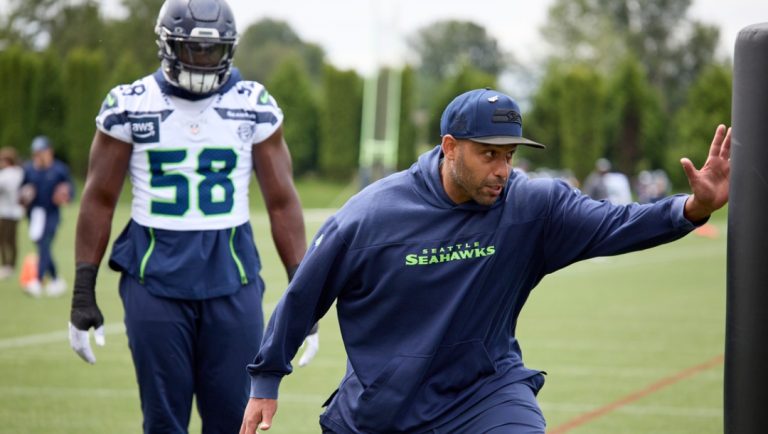 Seattle Seahawks defensive coordinator Aden Durde demonstrates a drill with linebacker Derick Hall, behind, during an NFL football practice, Wednesday, June 4, 2025, at the training facility in Renton, Wash.