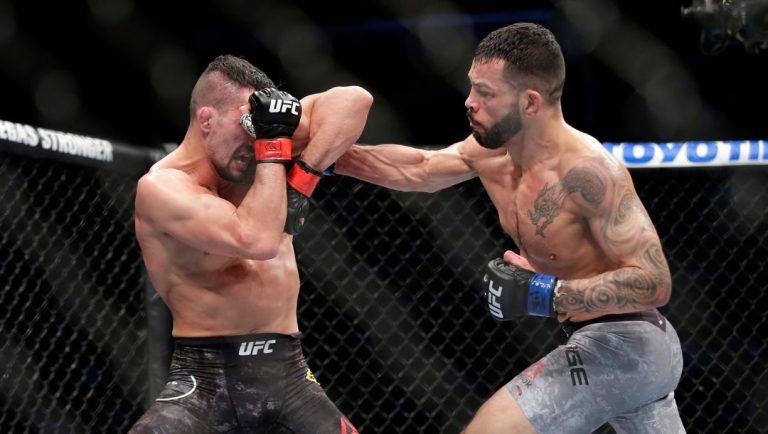 Mirsad Bektic, left, takes a punch by Dan Ige during a featherweight mixed martial arts bout at UFC 247 on Saturday.