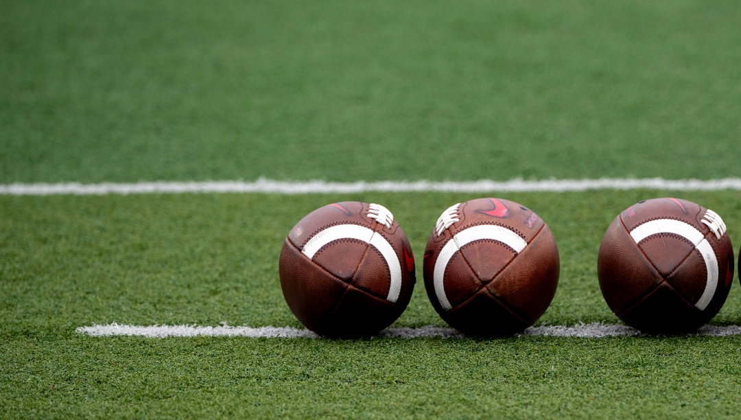 Footballs sit ready on the field before an NCAA football game on Saturday, Oct. 14, 2023, in Muncie, Ind. (AP Photo/Doug McSchooler)