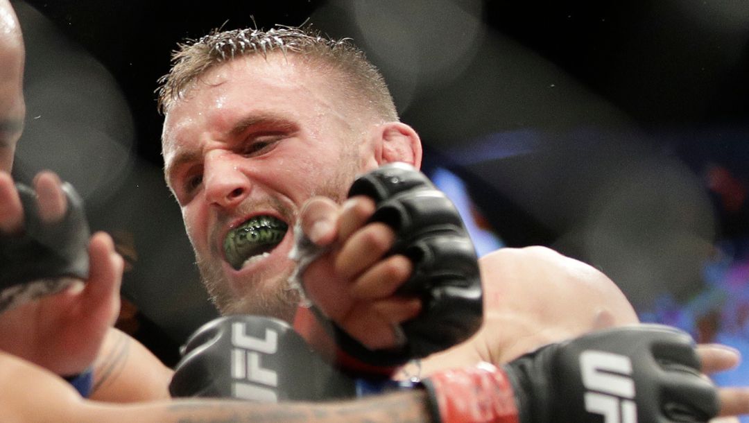 Tim Elliott, right, hits Demetrious Johnson during a mixed martial arts flyweight bout Saturday, Dec. 3, 2016, in Las Vegas.