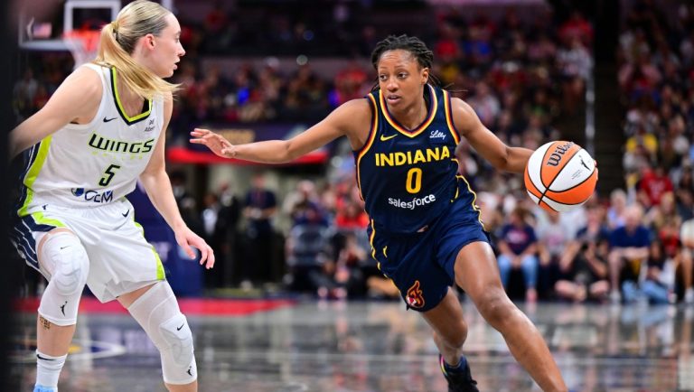 Indiana Fever's Kelsey Mitchell (0) goes to the basket against Dallas Wings' Paige Bueckers (5) during the second half of a WNBA basketball game, Sunday, July 13, 2025, in Indianapolis.