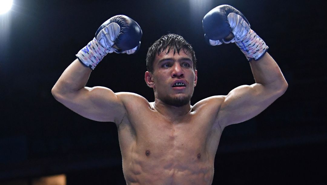 Uzbekistan's Murodjon Akhmadaliev, top, gestures celebrating his victory against Japan's Ryosuke Iwasa.