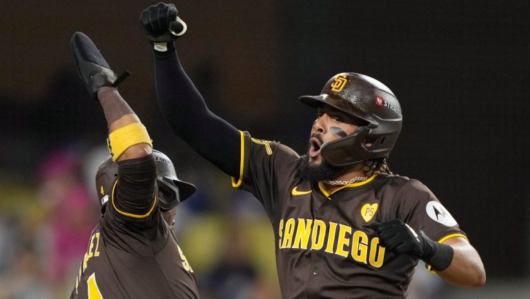 San Diego Padres' Fernando Tatis Jr., right, celebrates his solo home run with Luis Arraez (4) during the ninth inning in Game 2 of a baseball NL Division Series against the Los Angeles Dodgers, Sunday, Oct. 6, 2024, in Los Angeles.