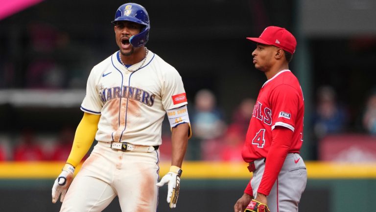 Seattle Mariners' Julio Rodriguez reacts to hitting an RBI double to score J.P. Crawford as Los Angeles Angels second baseman Christian Moore, right, look on during the fourth inning of a baseball game Sunday, Sept. 14, 2025, in Seattle.