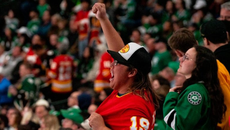A Calgary Flames fan cheers after their team scores another goal during the third period of an NHL hockey game against the Dallas Stars, Friday, Nov. 24, 2023, in Dallas.