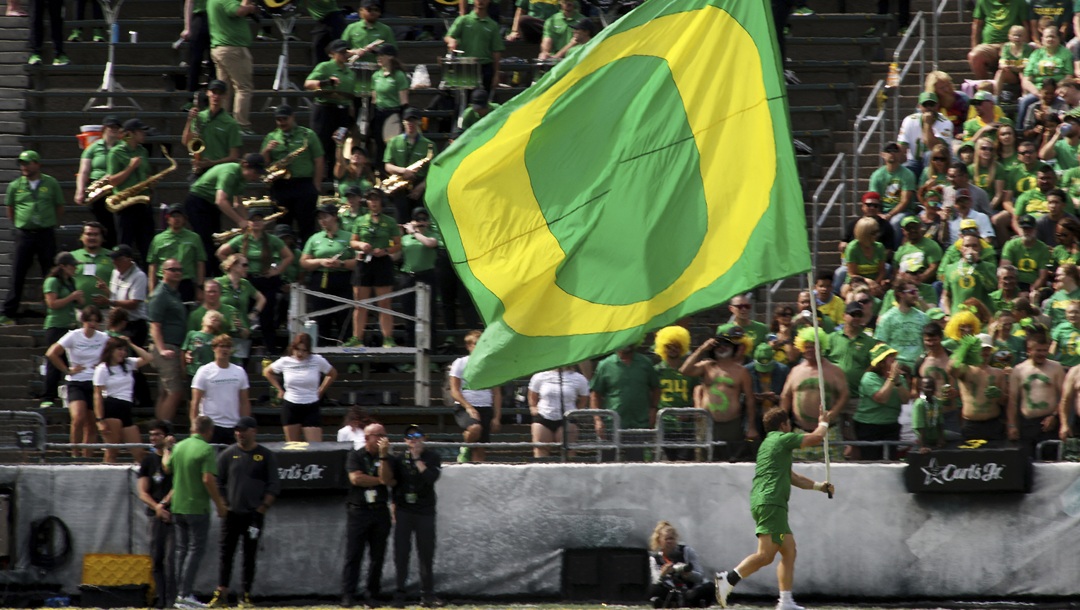 An Oregon flag bearer celebrates a score during the second half of an NCAA college football game against Oklahoma State, Saturday, Sept. 6, 2025, in Eugene, Ore.