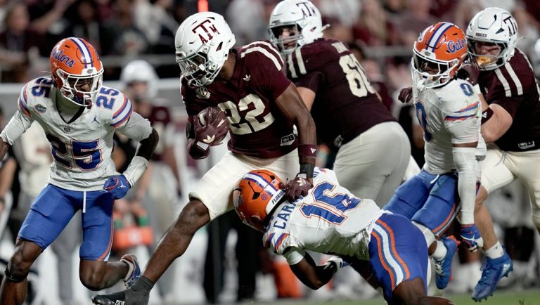 Texas A&M running back Ej Smith (22) tries to leap past Florida defensive back Micheal Caraway Jr. (16) before being tackled near the goal line during the second half of an NCAA college football game Saturday, Oct. 11, 2025, in College Station, Texas.