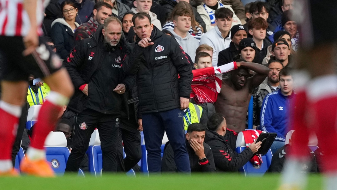Sunderland's head coach Regis Le Bris speaks to assistant coach Michael Proctor, left, during the English Premier League soccer match between Chelsea and Sunderland in London, Saturday, Oct. 25, 2025.