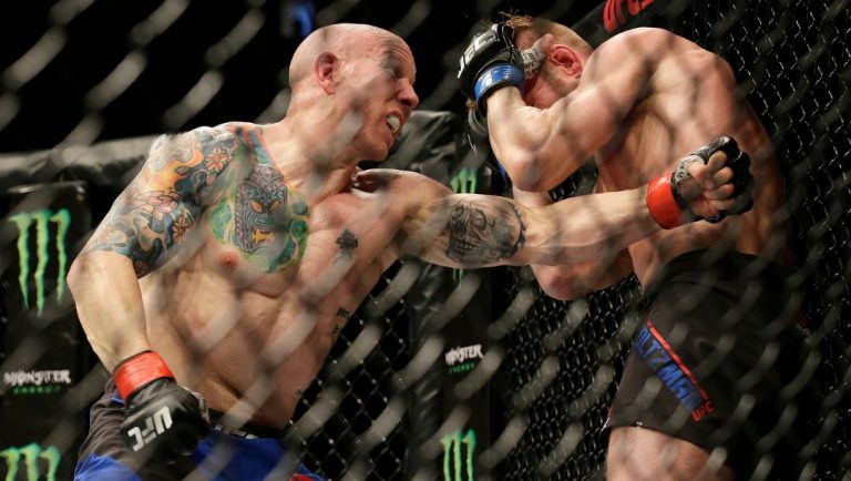 Josh Emmett, left, punches Scott Holtzman during a UFC Fight Night mixed martial arts fight in Sacramento, Calif., Saturday.