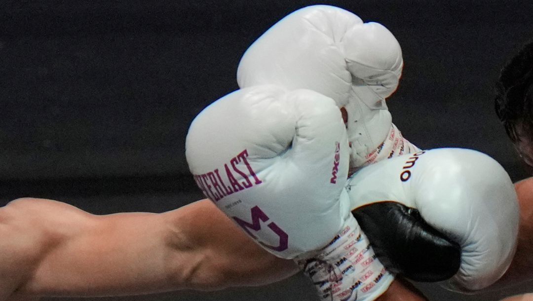 Japanese champion Naoya Inoue hits Uzbekistan's Murodjon Akhmadaliev in the second round of a boxing match.