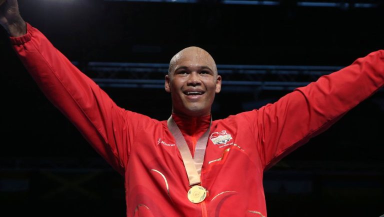 Gold medalist Frazer Clarke of England, center, celebrates on the podium as bronze medalist Patrick Malta of New Zealand.
