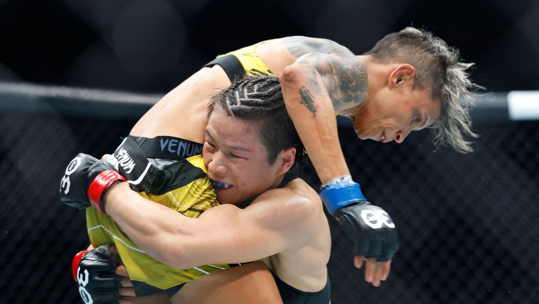 Zhang Weili lifts Amanda Lemos for a takedown during their UFC 292 Strawweight title mixed martial arts fight.