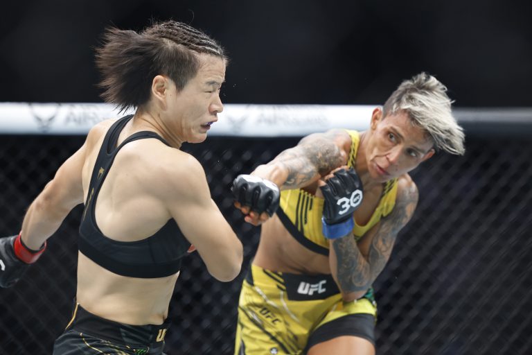 Zhang Weili absorbs a right hand from Amanda Lemos during their UFC 292 Strawweight title mixed martial arts fight.