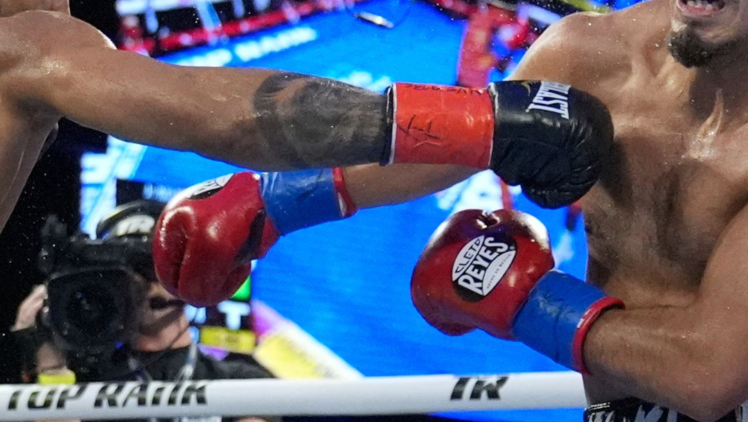 Dominican Republic's Elvis Rodriguez, left, punches Kendo Castaneda during their junior welterweight boxing bout.