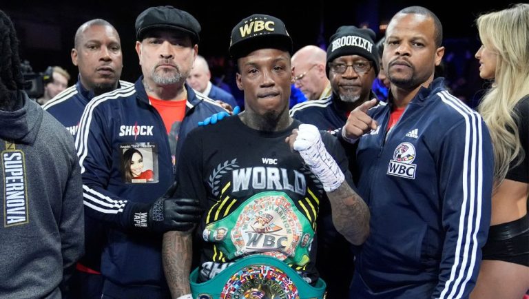 O'Shaquie Foster poses for photographs with his team after a junior lightweight championship boxing bout against Abraham Nova.