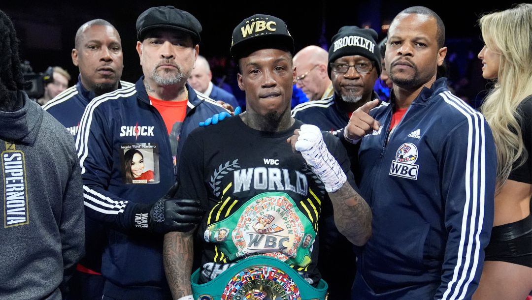O'Shaquie Foster poses for photographs with his team after a junior lightweight championship boxing bout against Abraham Nova.