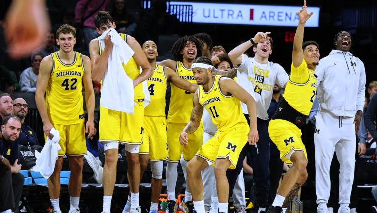Michigan bench celebrates a slam dunk by teammate Oscar Goodman (5), not pictured, during the second half of an NCAA college basketball game against Auburn Tuesday, Nov. 25, 2025, in Las Vegas.
