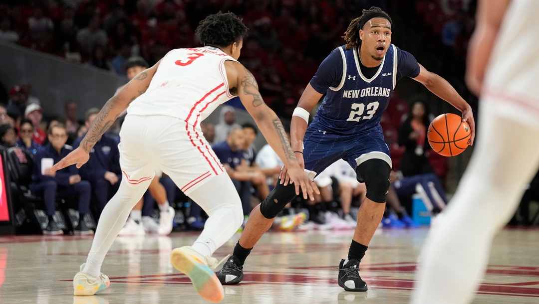 New Orleans forward MJ Thomas (23) controls the ball against Houston guard Ramon Walker Jr. (3) during the first half of an NCAA college basketball game, Saturday, Dec. 13, 2025, in Houston.