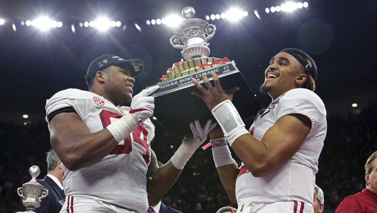 Alabama quarterback Jalen Hurts, right, and defensive lineman Da'Ron Payne (94) hold up the bowl trophy afterdefeating Clemson in the Sugar Bowl semi-final playoff game for the NCAA college football national championship, in New Orleans, Monday, Jan. 1, 2018. Alabama won 24-6 to advance to the national championship game.