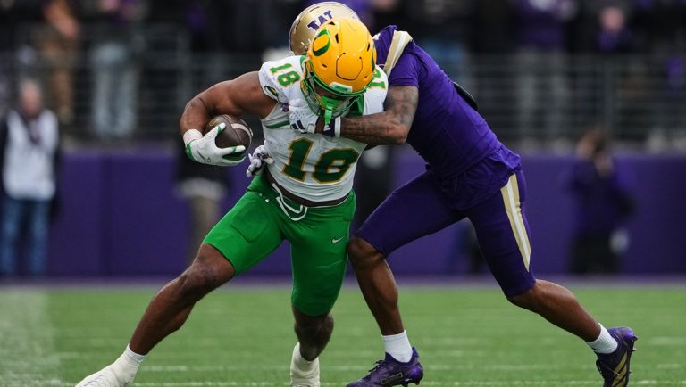 Oregon tight end Kenyon Sadiq (18) is tackled by a Washington player during the first half of an NCAA college football game, Saturday, Nov. 29, 2025, in Seattle.