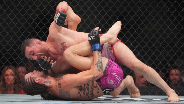 Georgia's Merab Dvalishvili grapples with Sean O'Malley during the third round of a bantamweight title bout at the UFC 316.