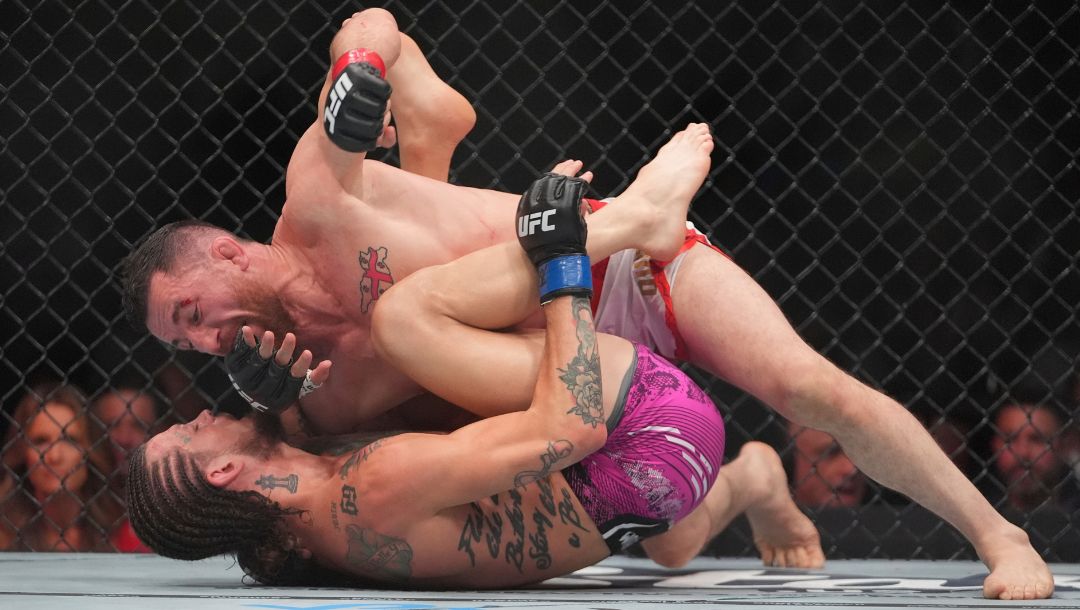 Georgia's Merab Dvalishvili grapples with Sean O'Malley during the third round of a bantamweight title bout at the UFC 316.