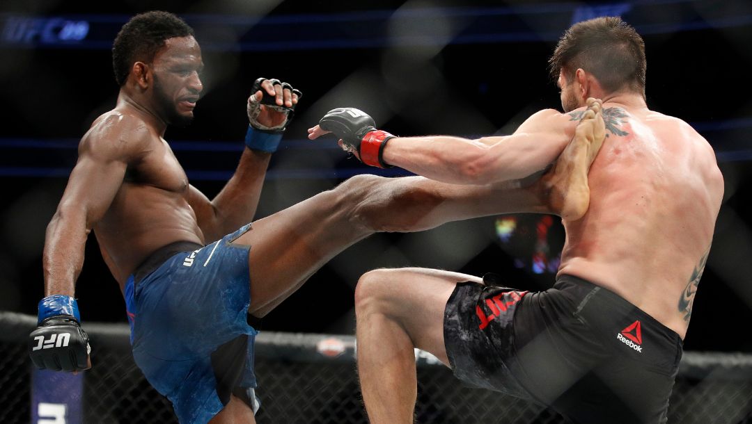 Neil Magny, left, kicks Carlos Condit during a welterweight mixed martial arts bout at UFC 219, Saturday, Dec. 30, 2017.